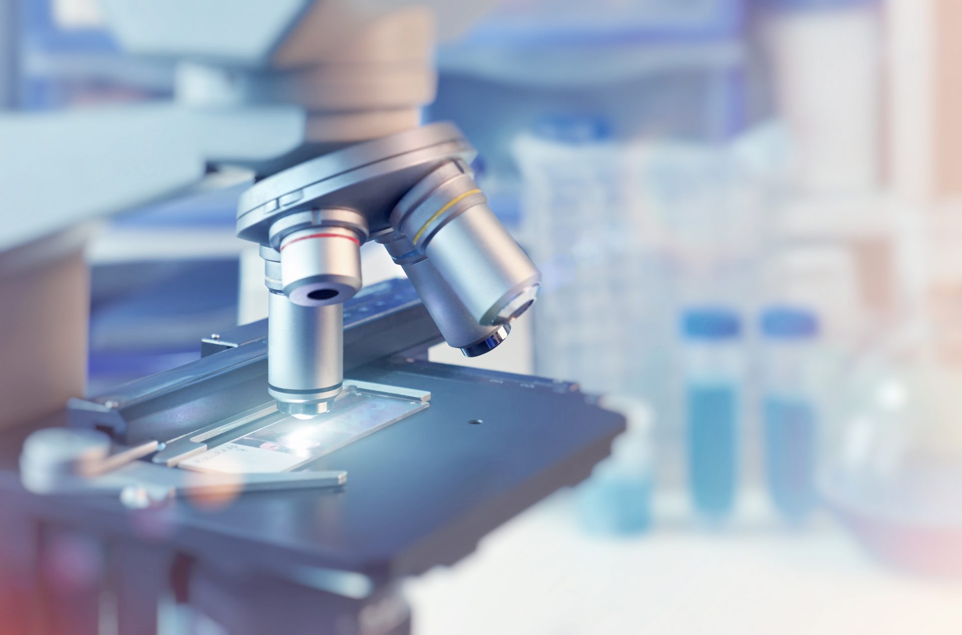 Scientific background with closeup on light microscope and blurr